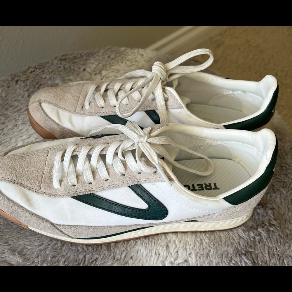 Tretorn white sneakers with green trim.